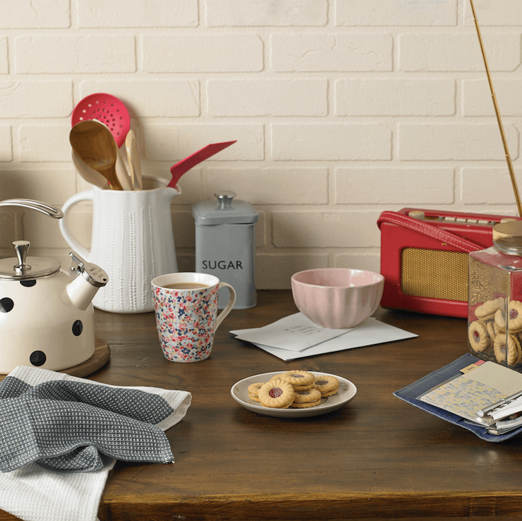 Jammy Dodgers on a plate with a cup of tea