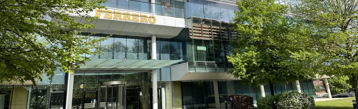 Outside of Ferrero office building on a sunny day with trees in front 