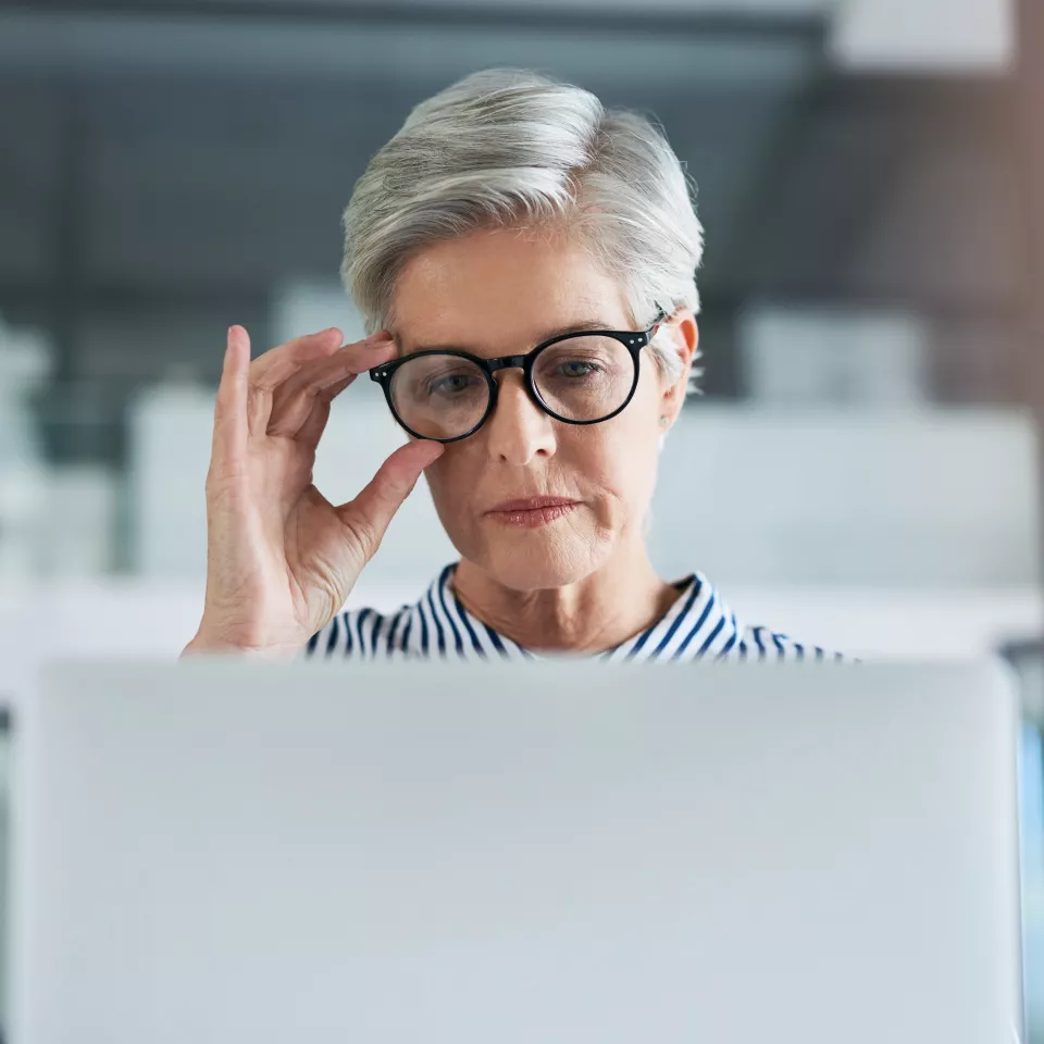 Woman with glasses looking at a screen