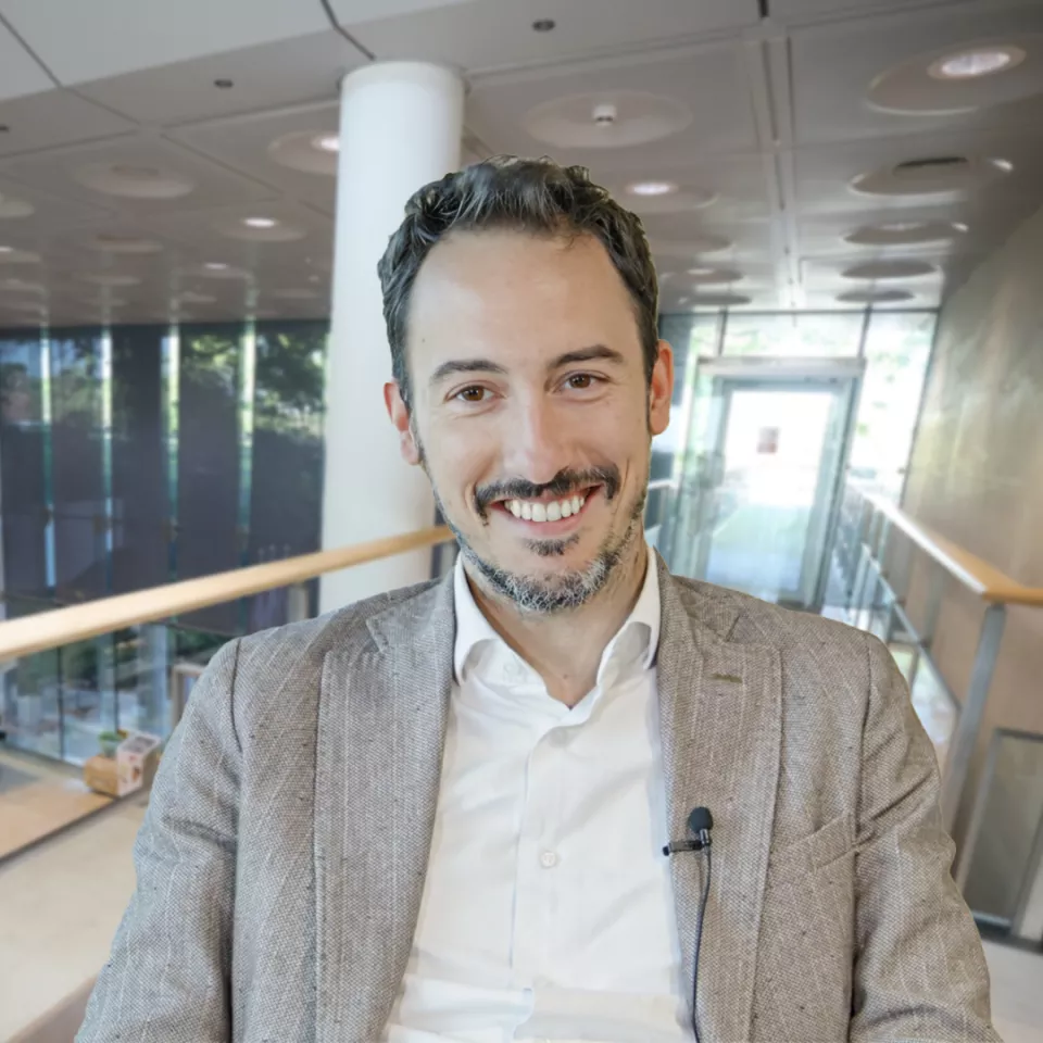Man on an upper walkway in the Greenford office smiling 