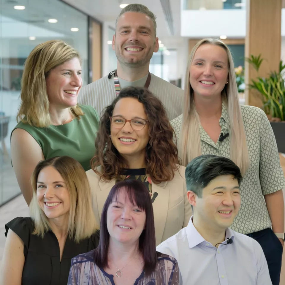 A group of male and female colleagues smiling 