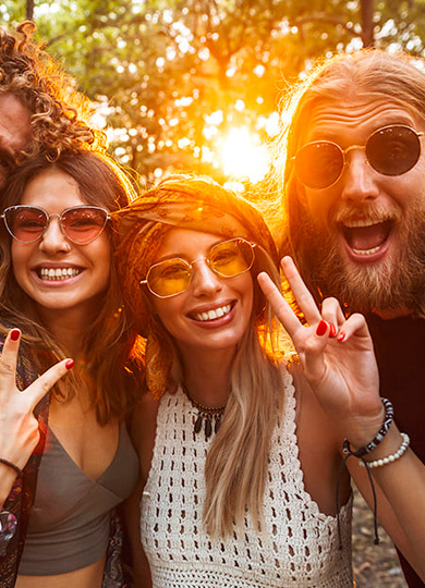 A group of smiling friends making victory gestures.