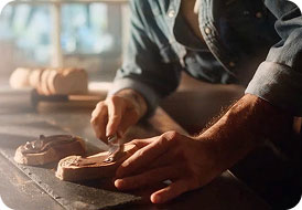 Hands spreading Nutella on bread on a wooden work surface
