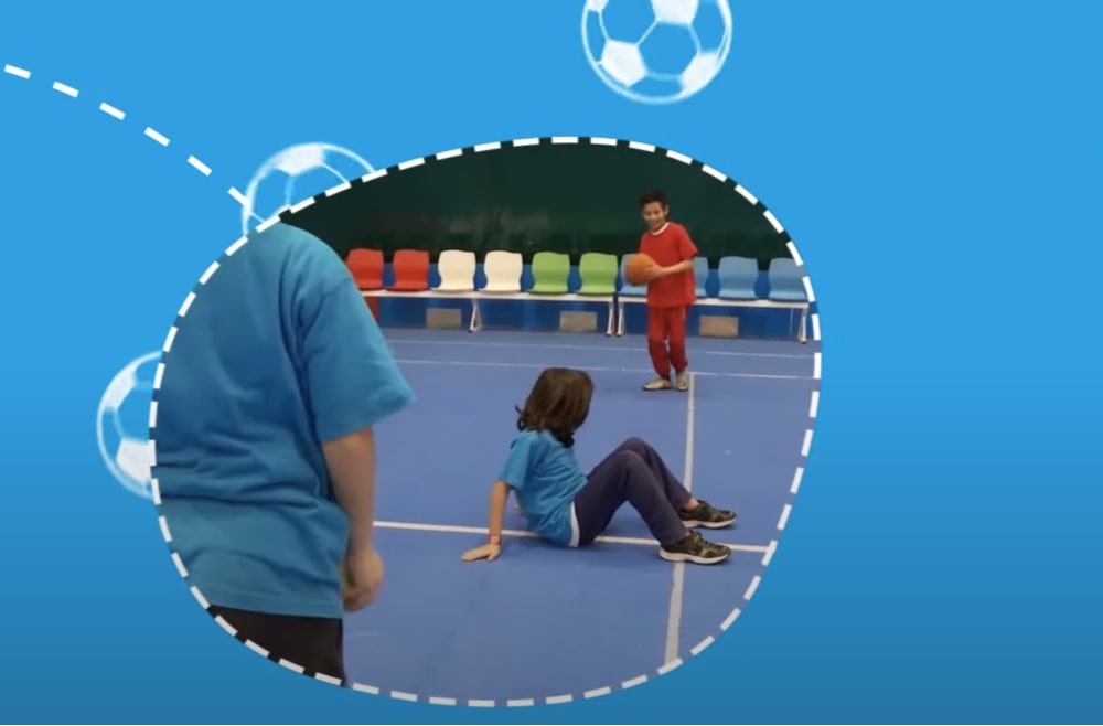 Three boys playing elastic bridge with a ball