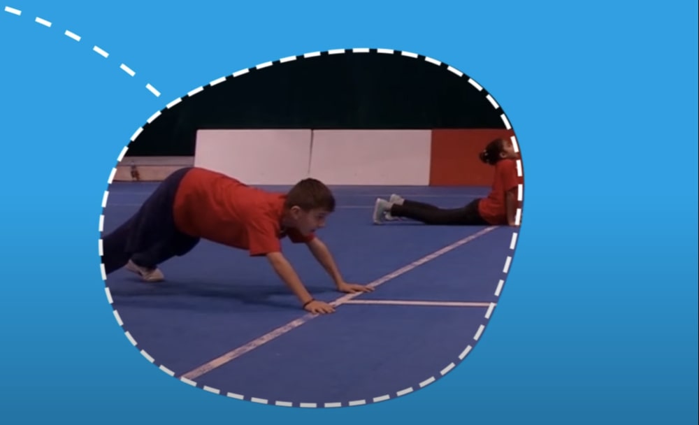 Boy on all fours in sports hall.