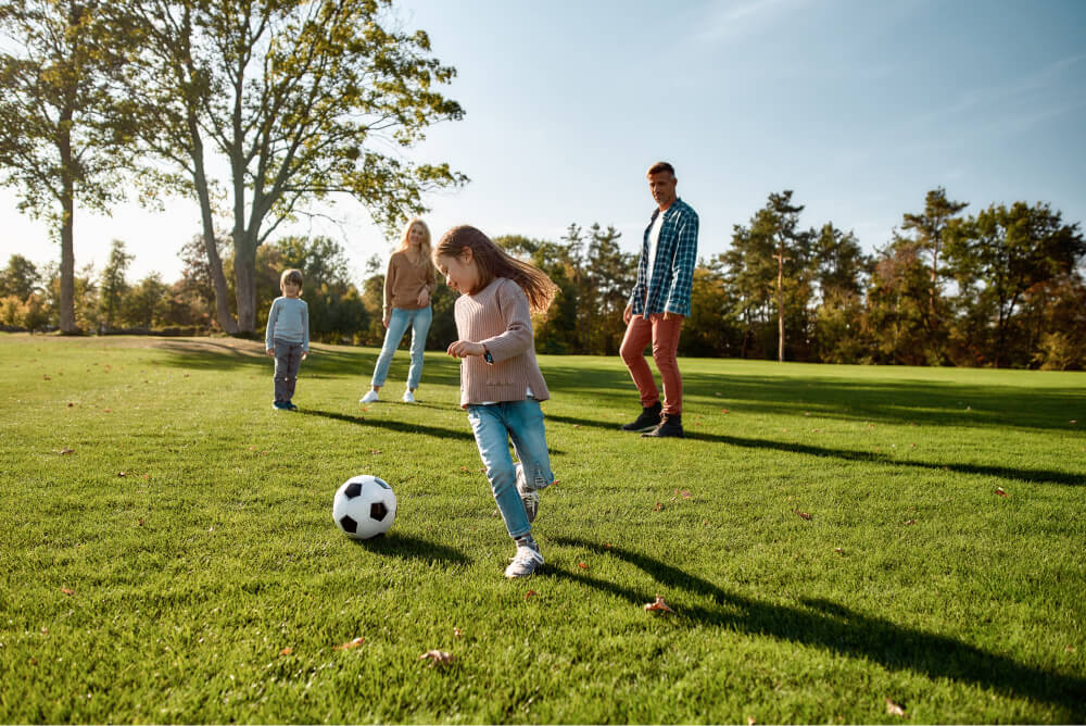 Little girl playing football with her family