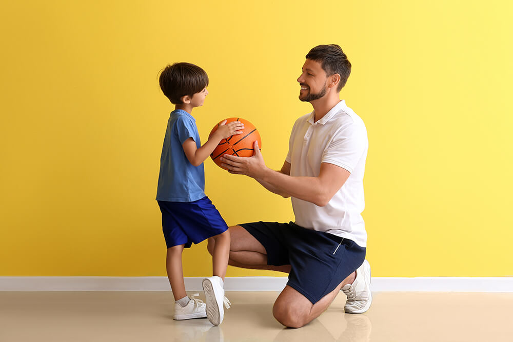 Man and child holding a ball