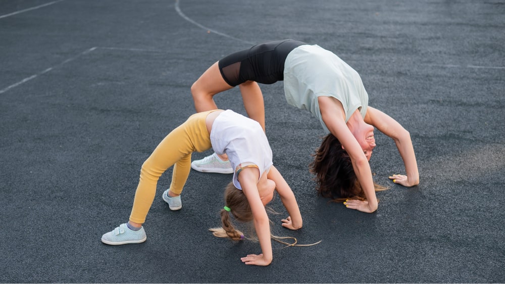 Mother and daughter do bridge exercise.