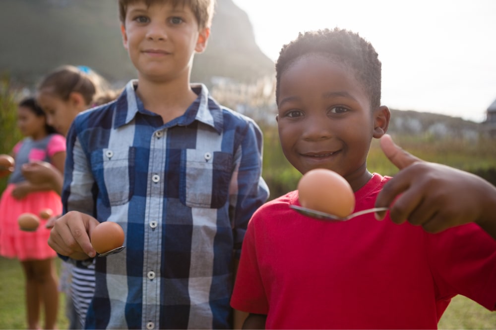 Two boys playing egg and spoon