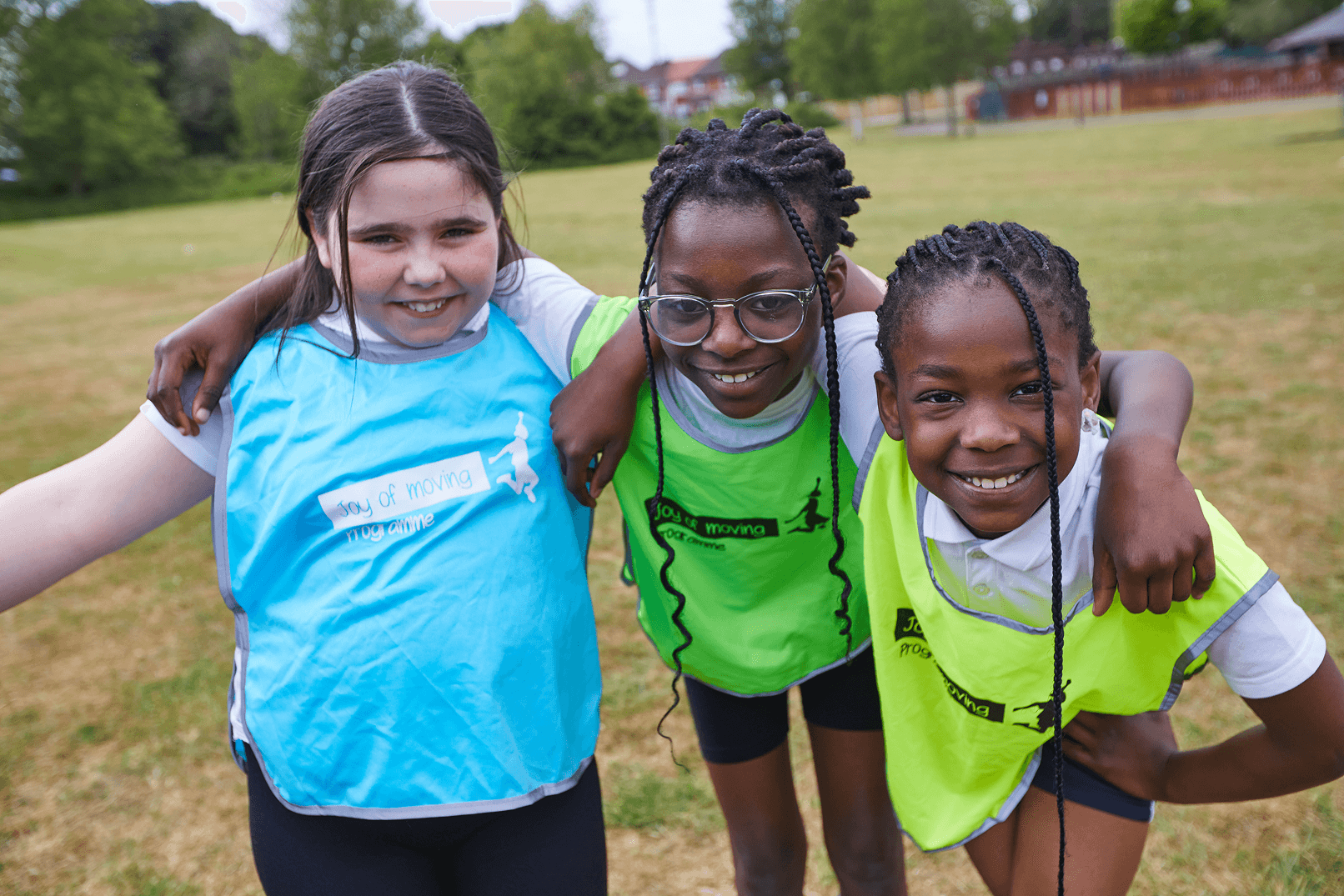 3 young people smiling in sports bibs
