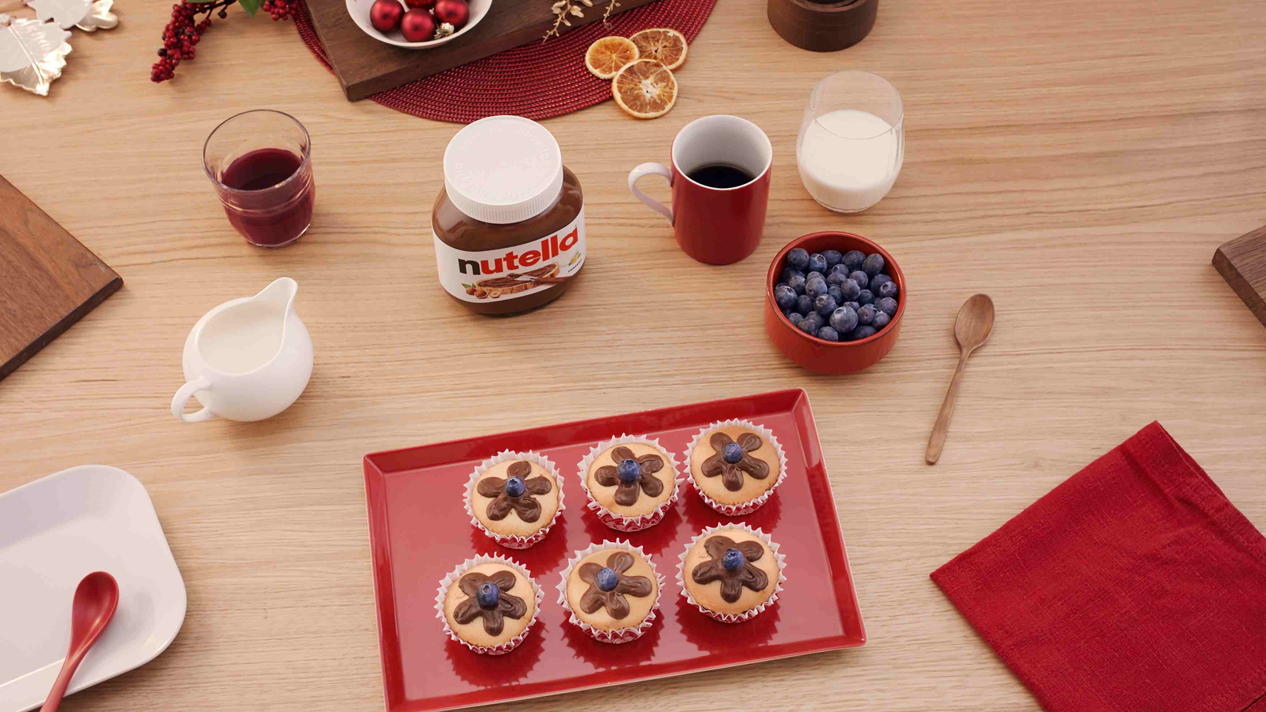 Festive cupcakes decorated with Nutella frosting flowers and topped with blueberries