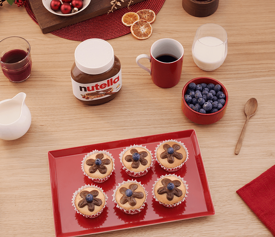 Festive cupcakes decorated with Nutella frosting flowers and topped with blueberries
