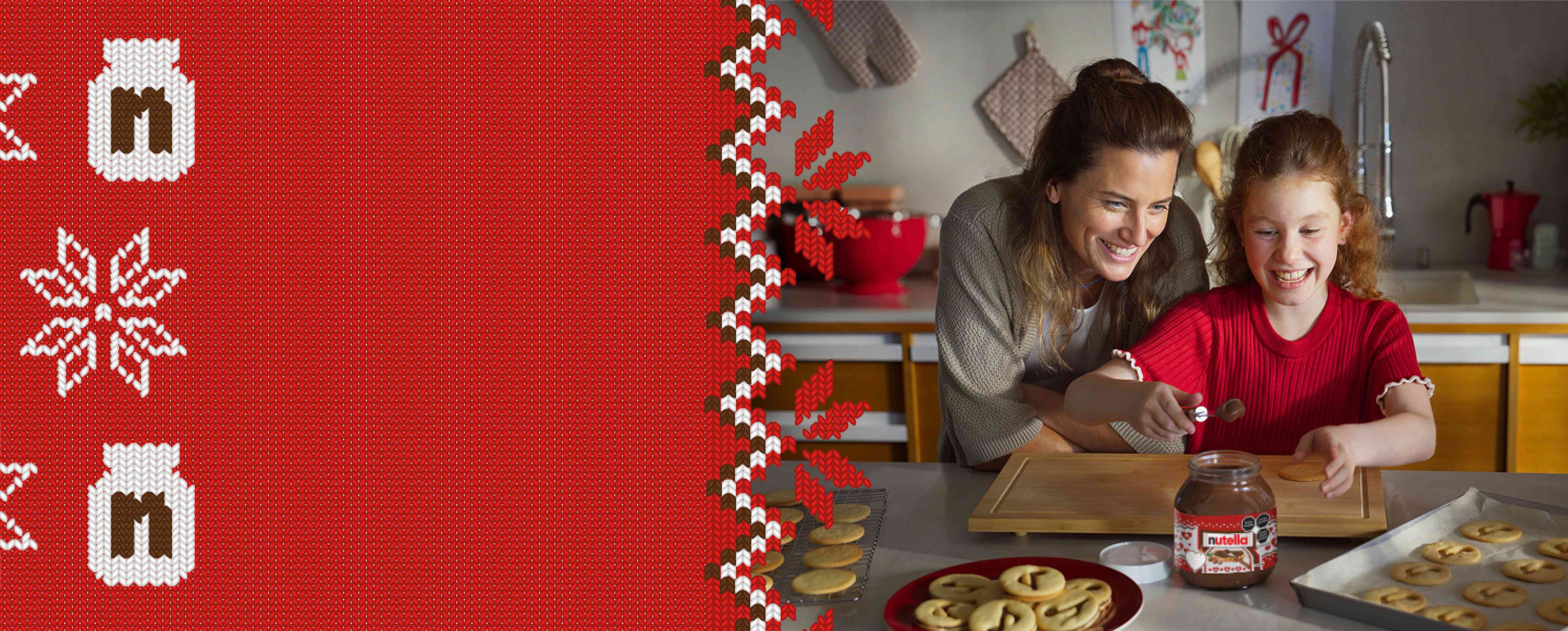 A young girl is using a spoon to scoop Nutella® out of a jar to decorate Nutella® biscuits, while her mother watches over her shoulder.
