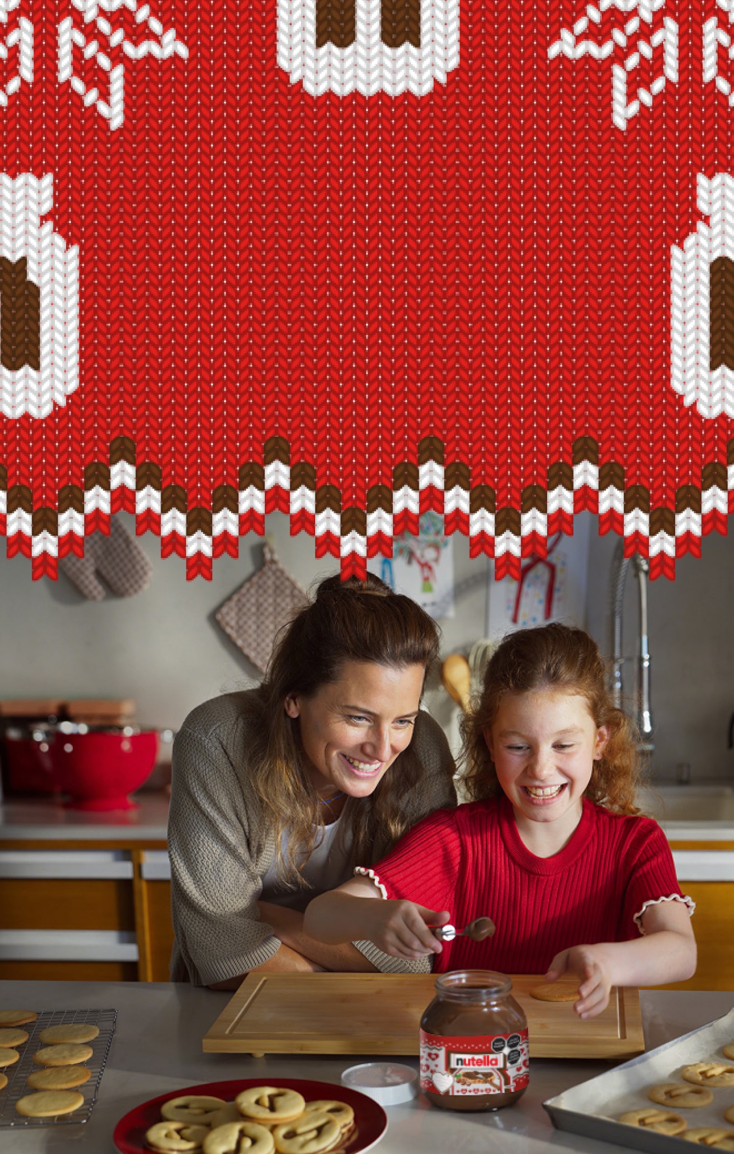A young girl is using a spoon to scoop Nutella® out of a jar to decorate Nutella® biscuits, while her mother watches over her shoulder.